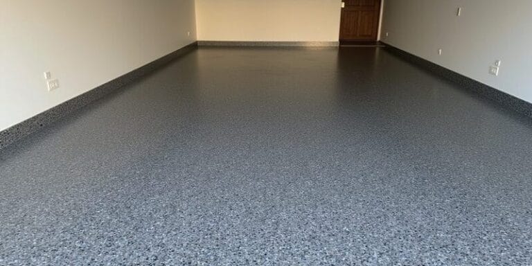 Grey epoxy flake garage floor coating in Bristol with seamless finish and flake cove skirting along the walls.